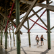 A couple and their dog take stroll along the beach near Charleston, South Carolina.